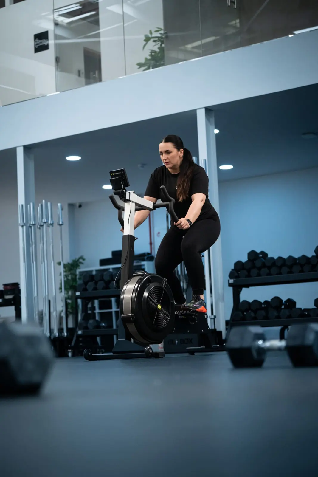 Athlete sprinting on an air bike in a gym