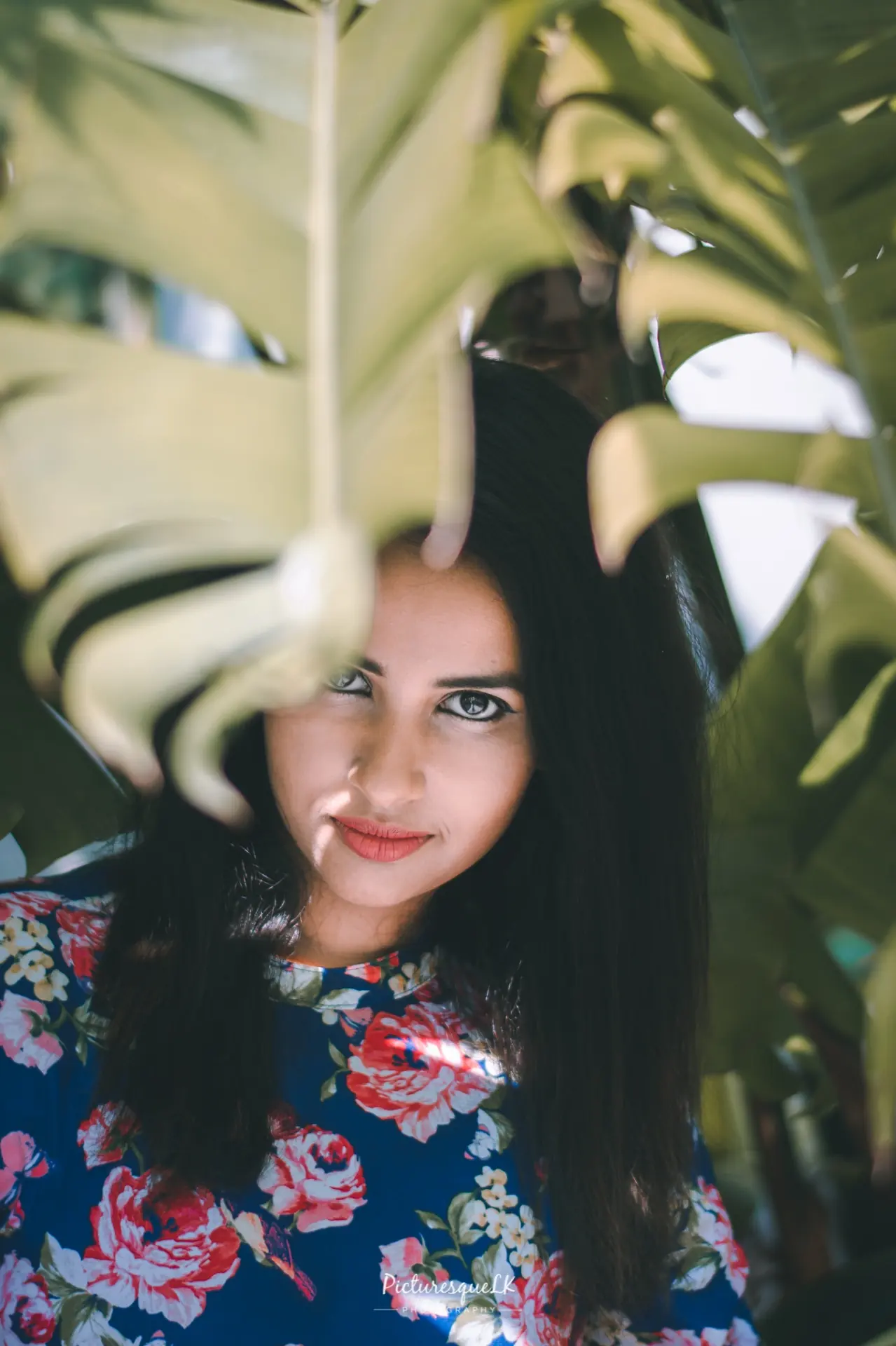 Portrait framed through tropical leaves